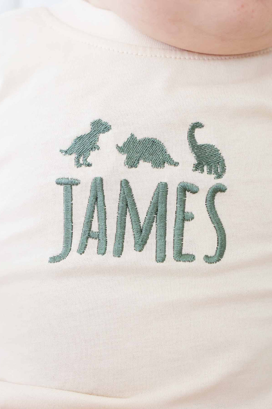 natural tan green thread dinosaur and name embroidered long sleeve bubble romper for babies and toddlers