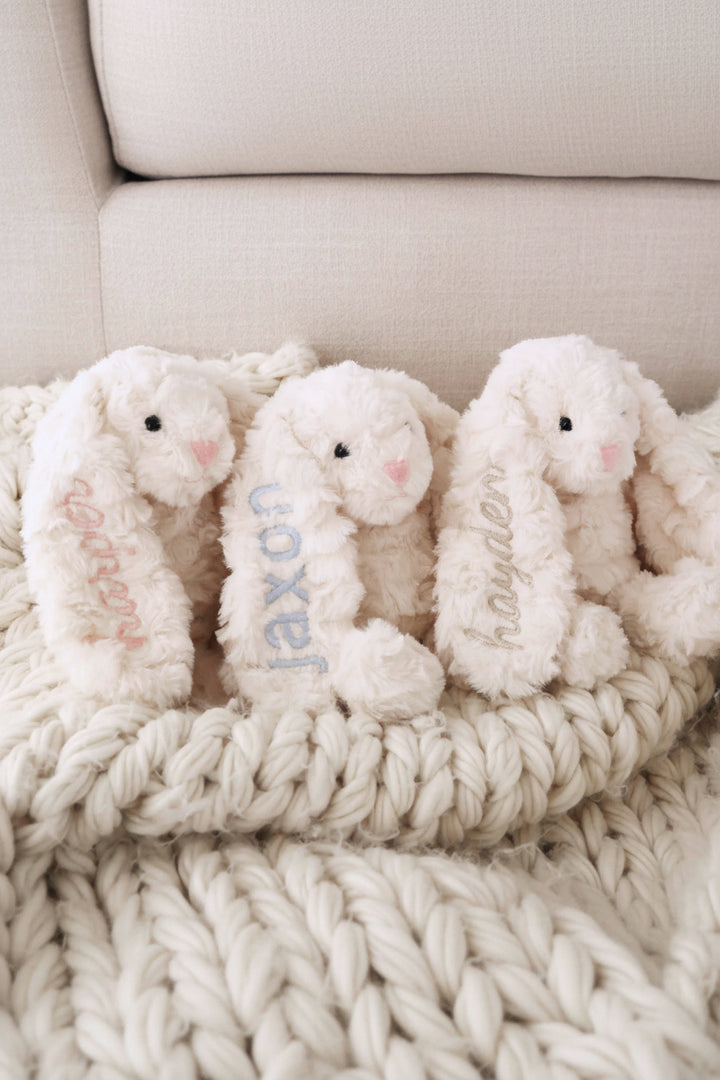 3 personalized stuffed animal bunnies with names embroidered on them in block and script fonts