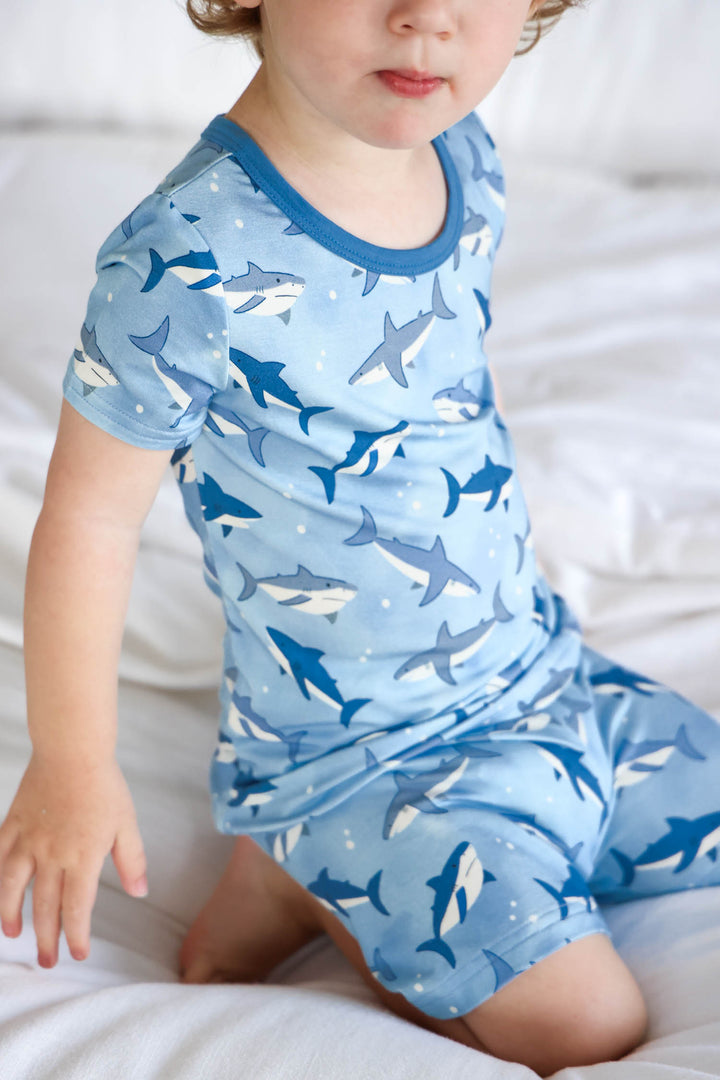 boy kneeling on bed in fin friends pajama set