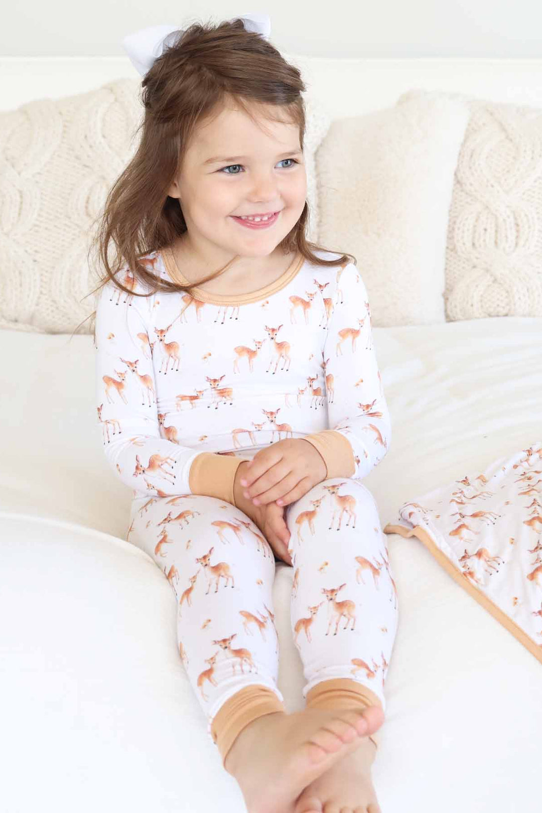 girl wearing a long sleeve and pant two piece pajama set with deer and mushroom 