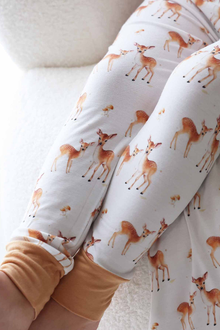 Boy in soft woodland pajama set posing with a coordinating deer stuffed toy