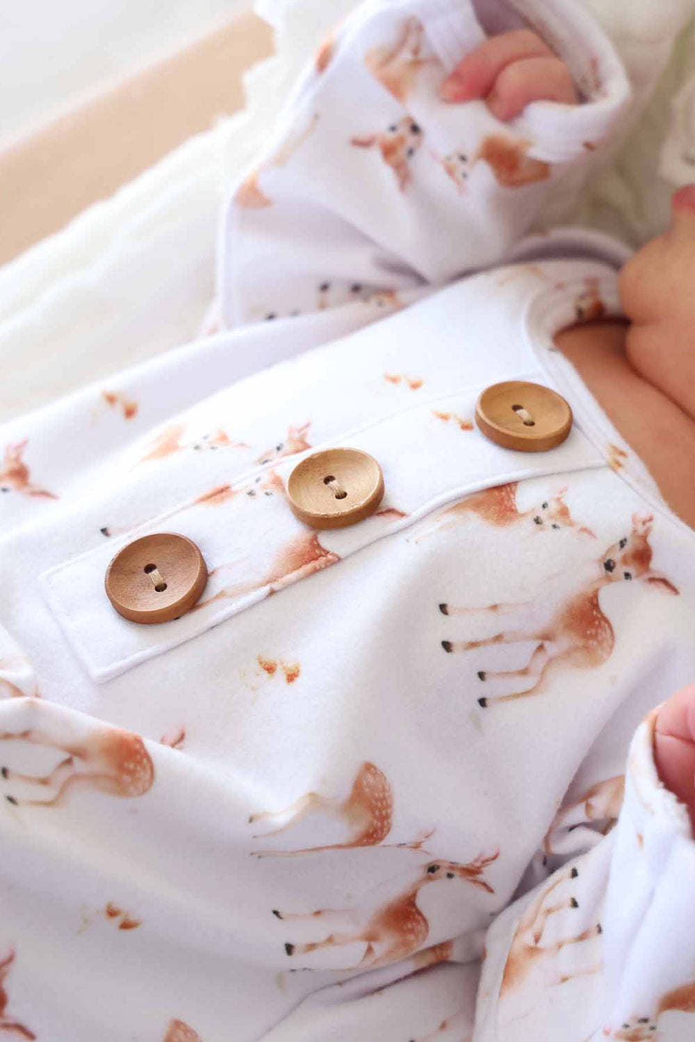 white knot gown with fawns and three wooden buttons on the front 