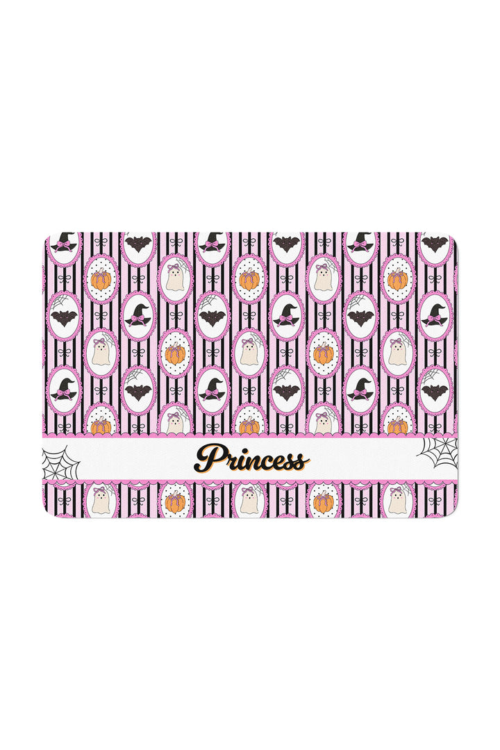 Personalized pink and black Halloween pet placemat with pumpkin, bat, and witch hat pattern, customized with the name 'Princess' in cursive.