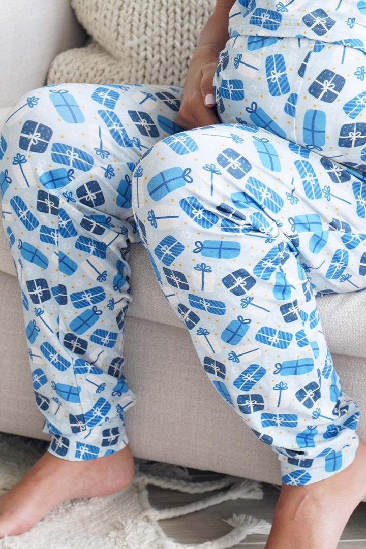 Person wearing Caden Lane blue and white patterned pajama pants sitting on a couch.