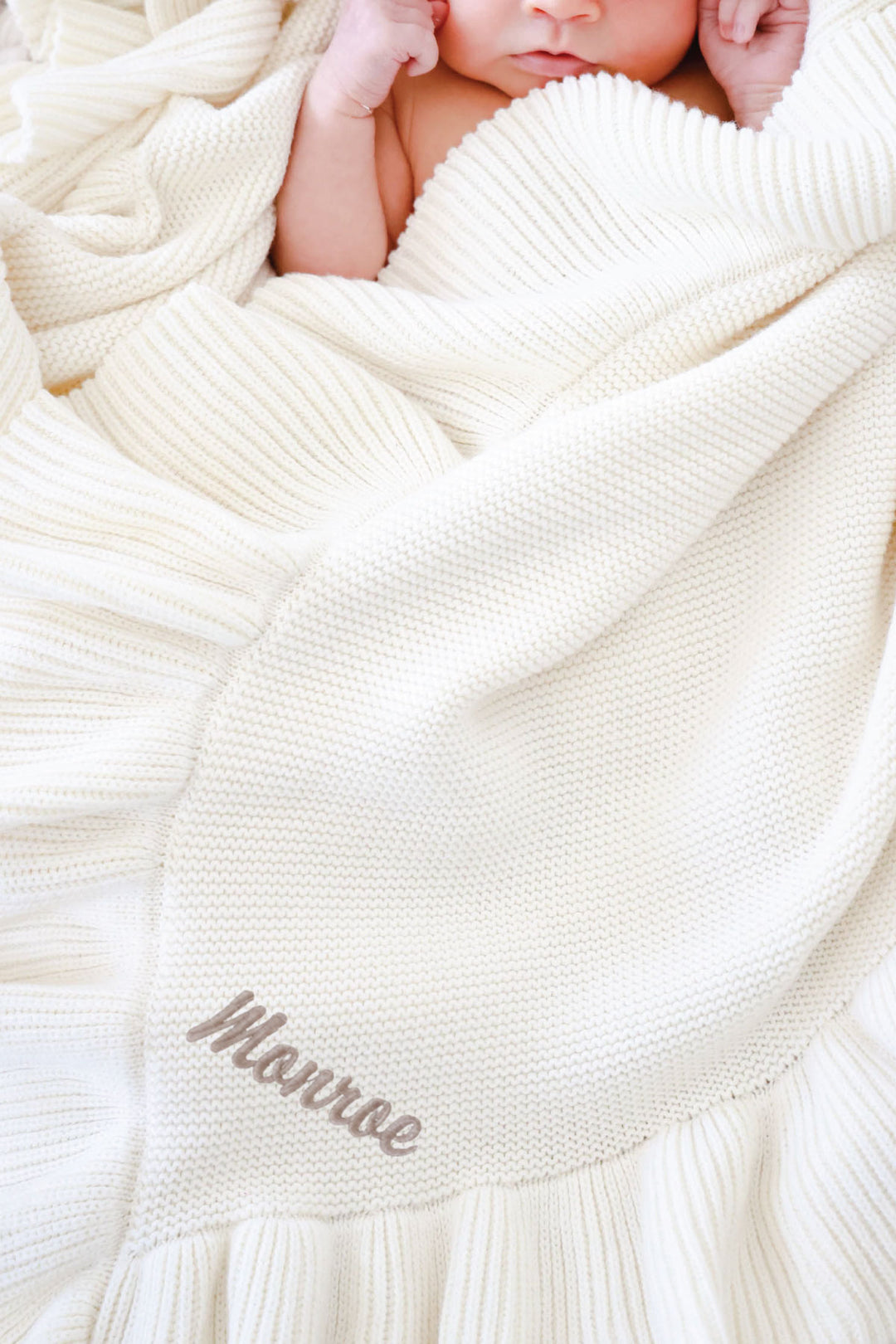 closeup of ivory ruffle blanket with embroidered name
