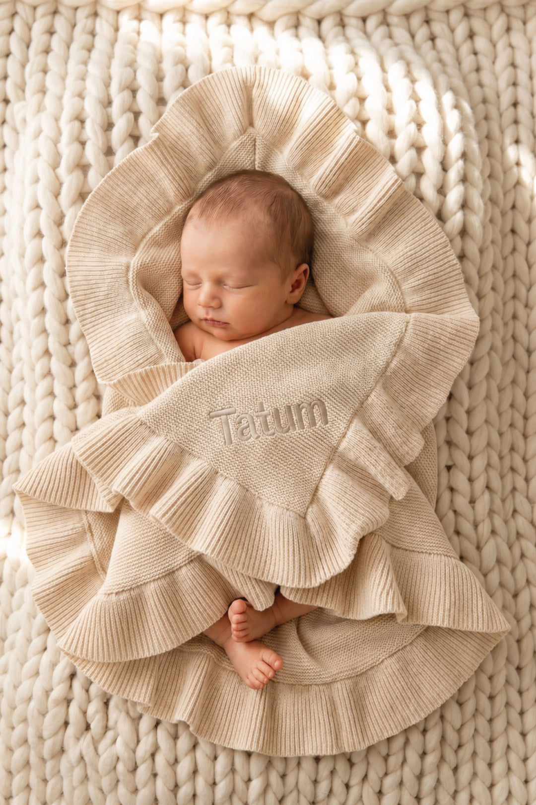 baby wrapped up in personalized knit blanket in tan with block font