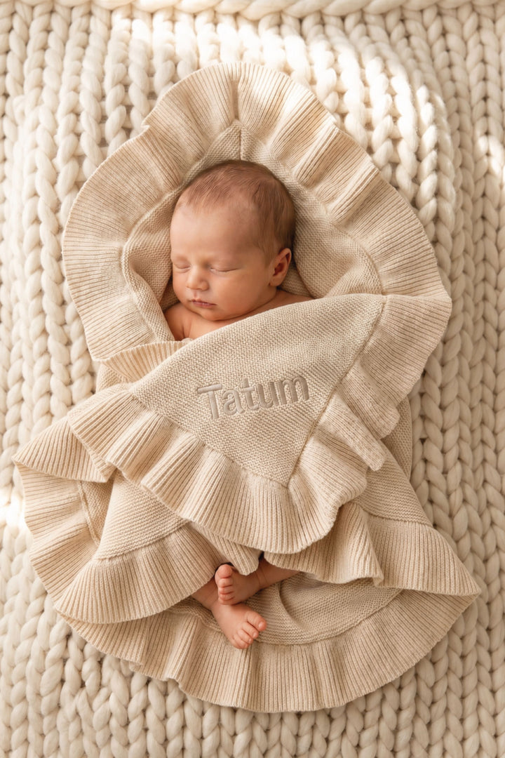baby wrapped up in personalized knit blanket in tan with block font