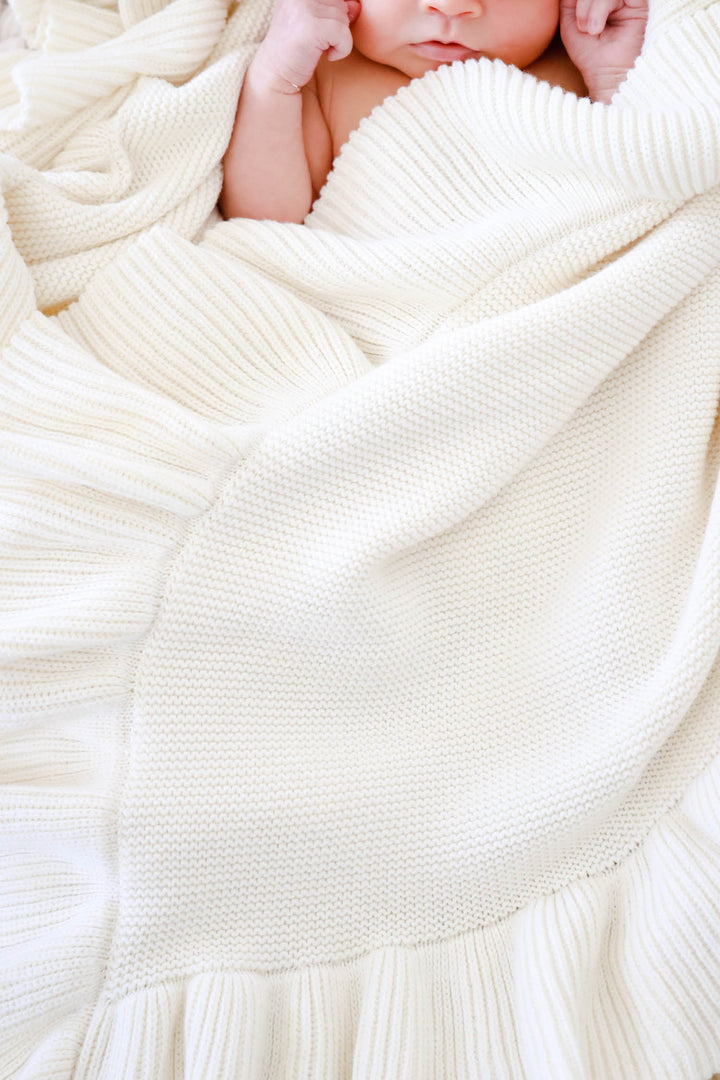 closeup of ivory knit blanket for newborns 