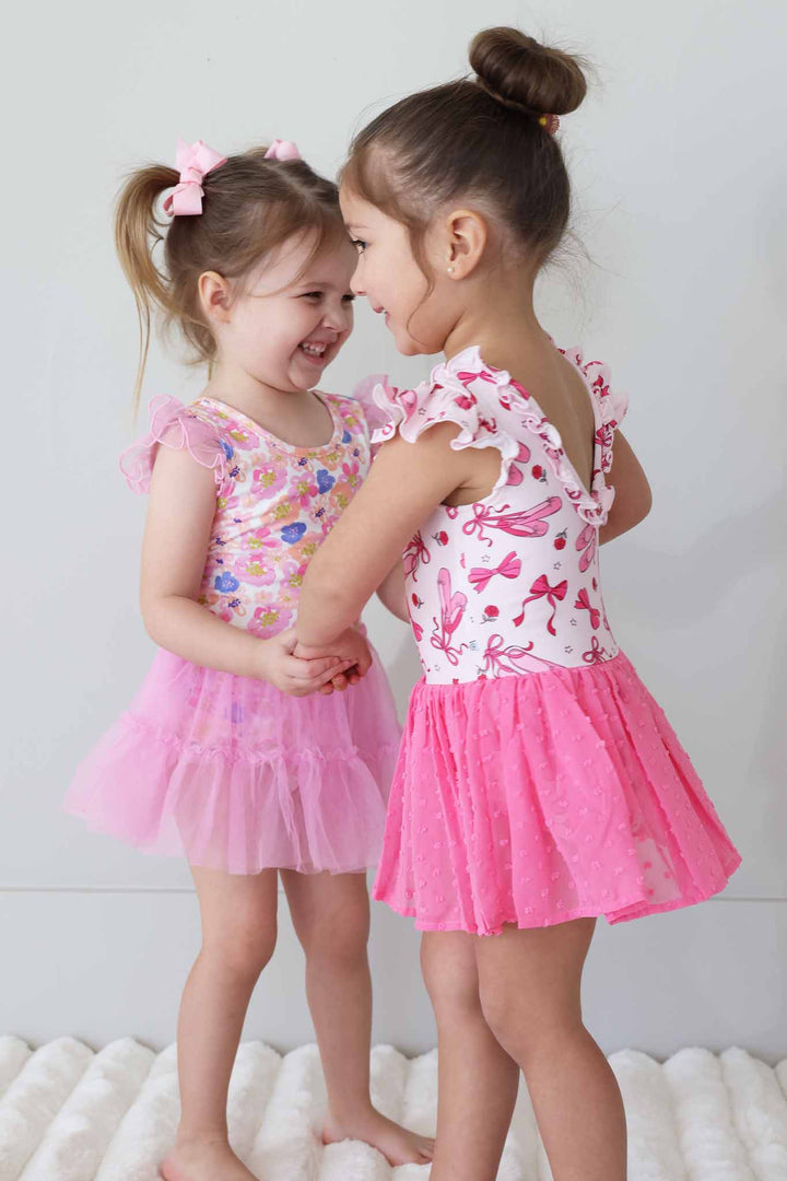 girls twirling around in leotards with tulle skirts 
