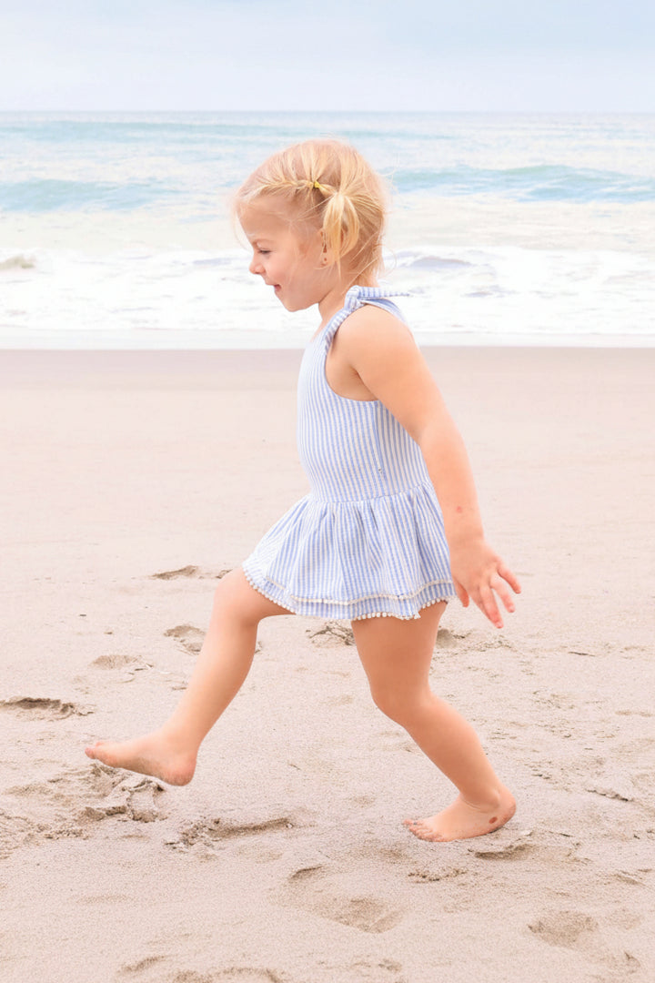 classic seersucker blue swimsuit with tiered skirt and pom pom details for little girls