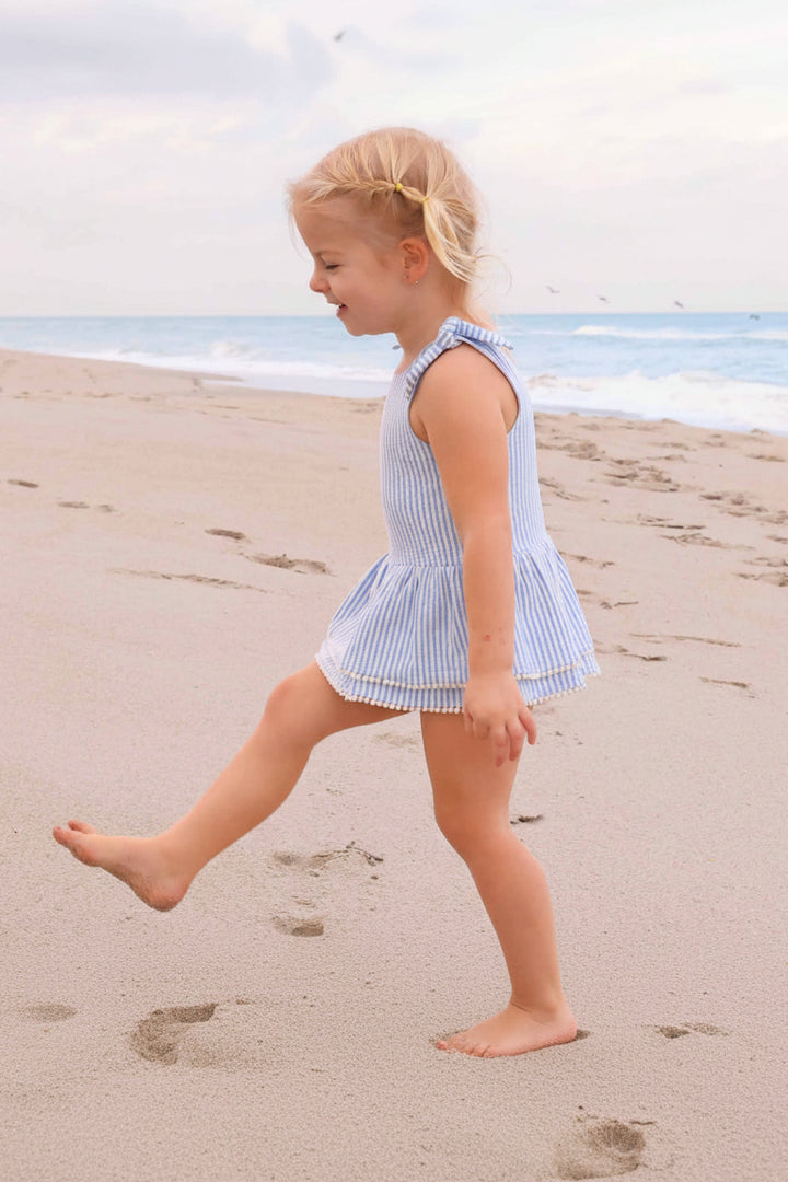 cute dress with tiered seersucker skirt and white pom trim