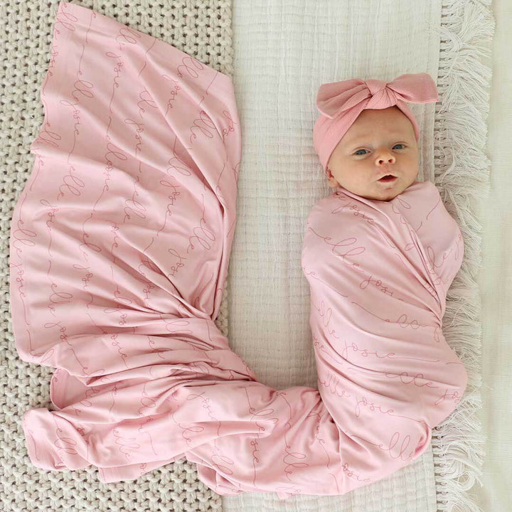 personalized light rose on pink baby name swaddle blanket all script 