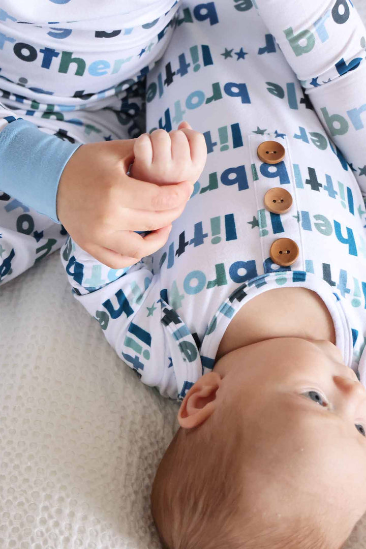 boy in big brother two-piece pajamas with newborn wearing little bother knot gown