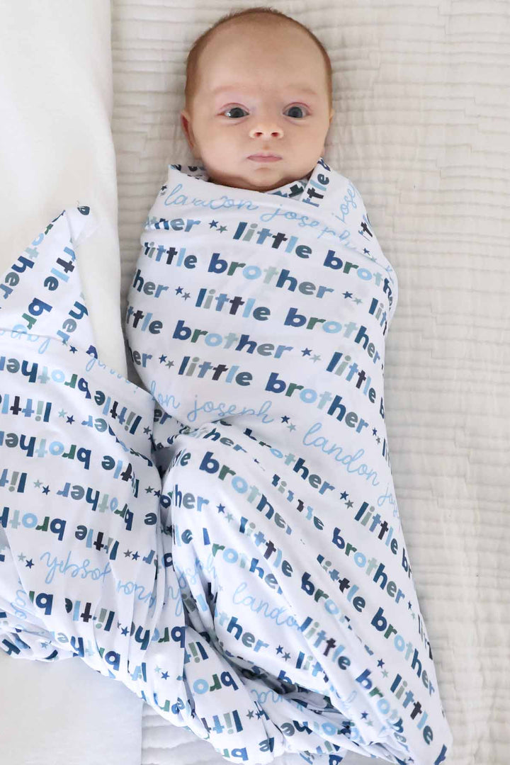 newborn wearing little brother personalized swaddle