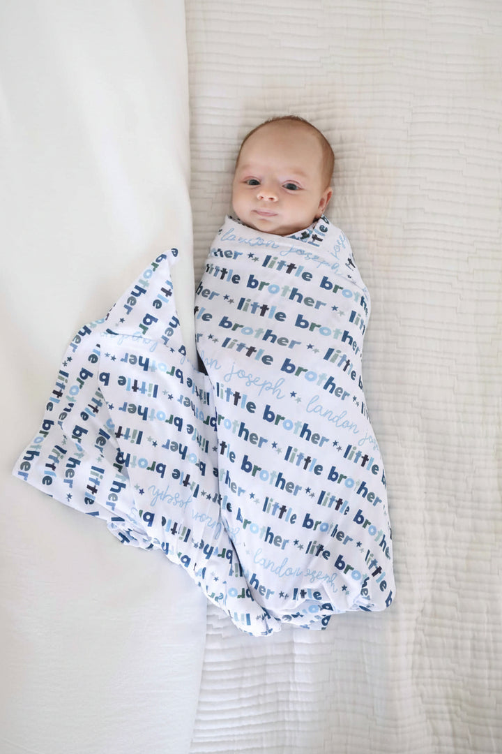newborn wearing little brother personalized swaddle