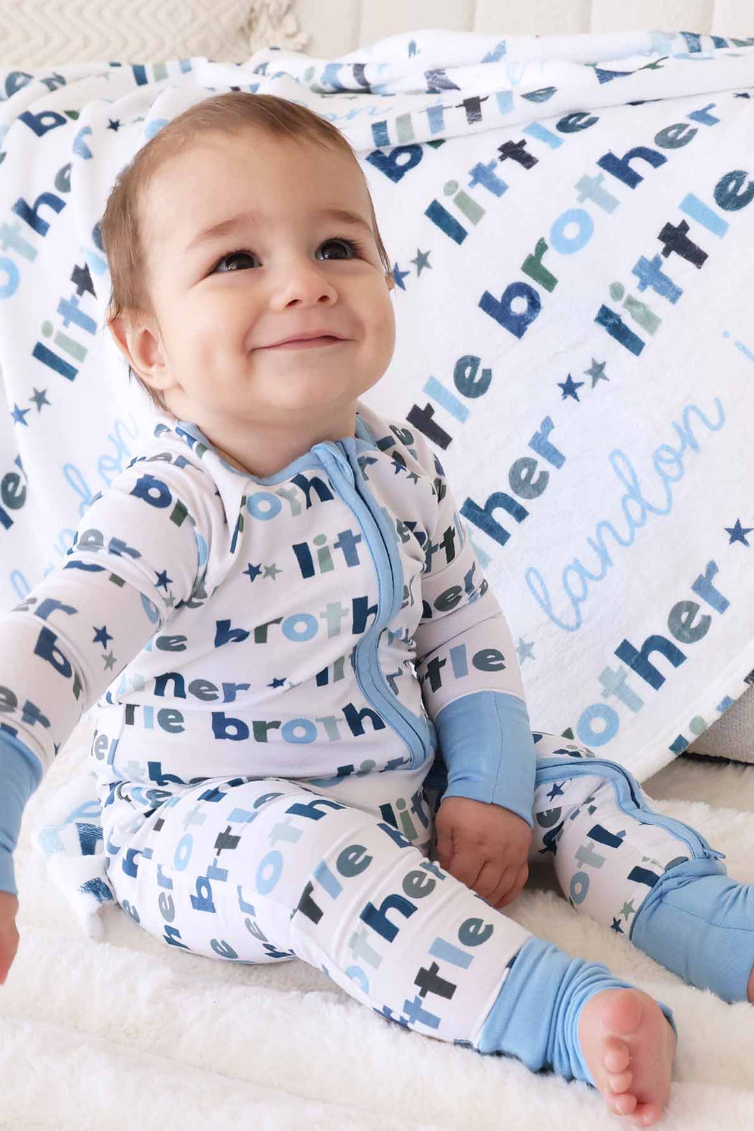 boy with matching little brother zip romper and personalized blanket