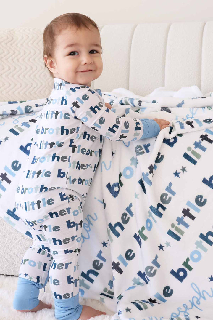 boy with matching little brother zip romper and personalized blanket