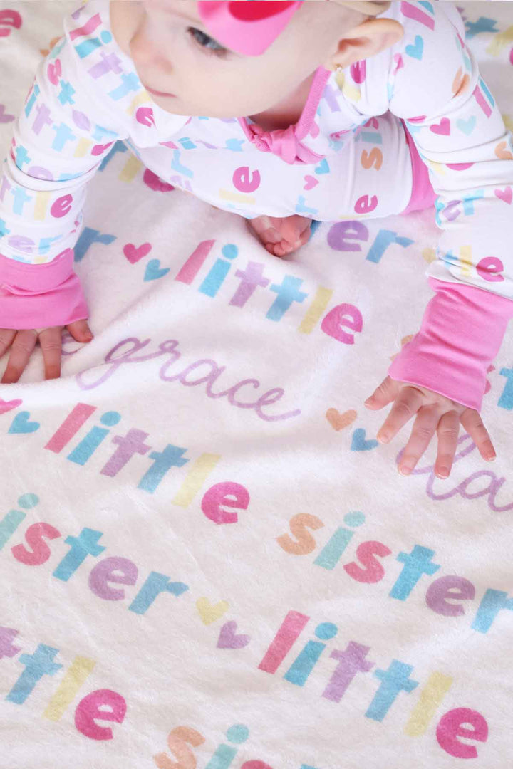 little girl crawling on the personalzied little sister blanket