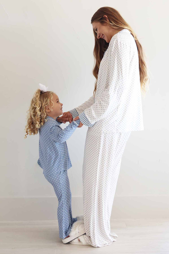 girl standing on her mom's feet wearing a long sleeve flare pants lounge sets with polka dots in inverted colors: dusty blue and white 