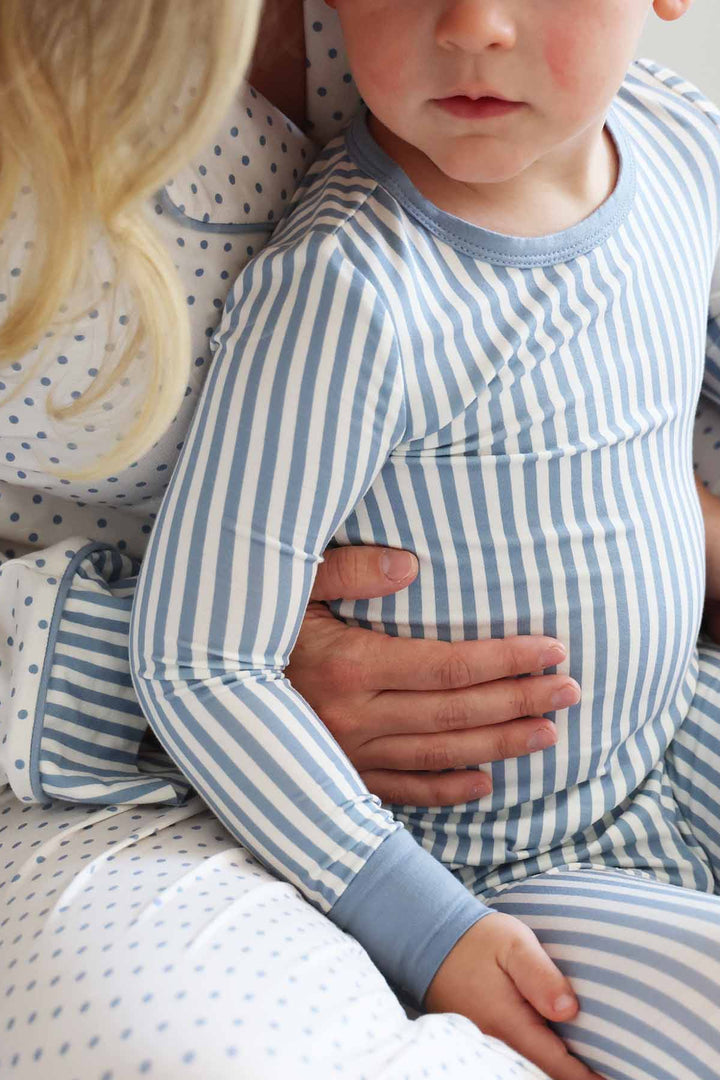 close up of blue and white stripe long sleeve pajama set for boys with a coordinating lounge set for mom with polka dots 