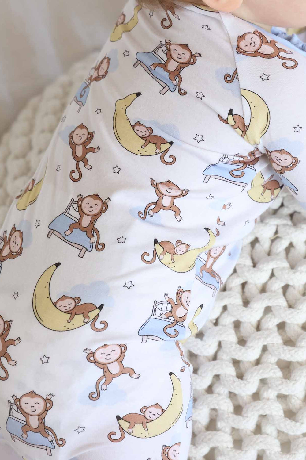 close up of pajamas with monkey sleeping on banana moon and jumping on bed 
