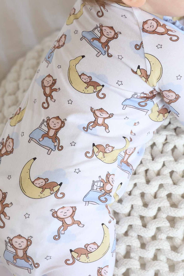 close up of pajamas with monkey sleeping on banana moon and jumping on bed 