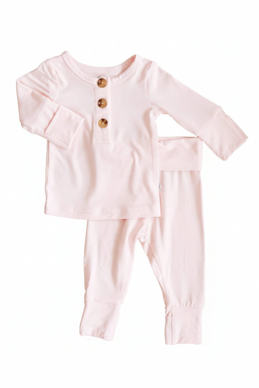 Caden Lane Pale Pink baby outfit with buttons on a white background