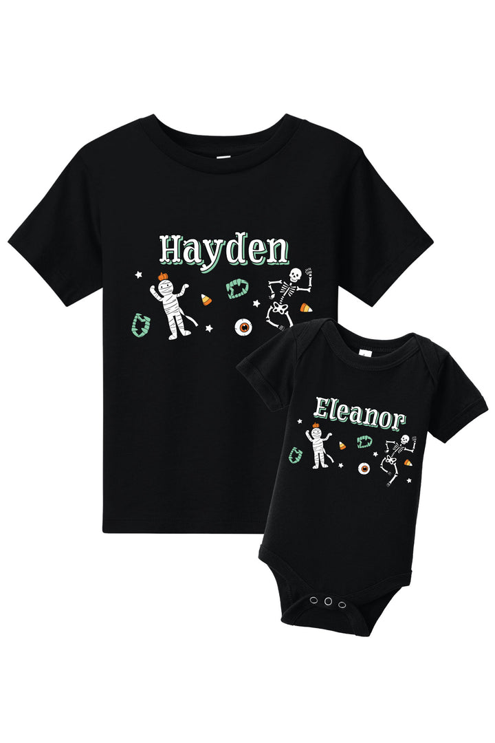 Black t-shirt and baby onesie with personalized names and graphics on a white background