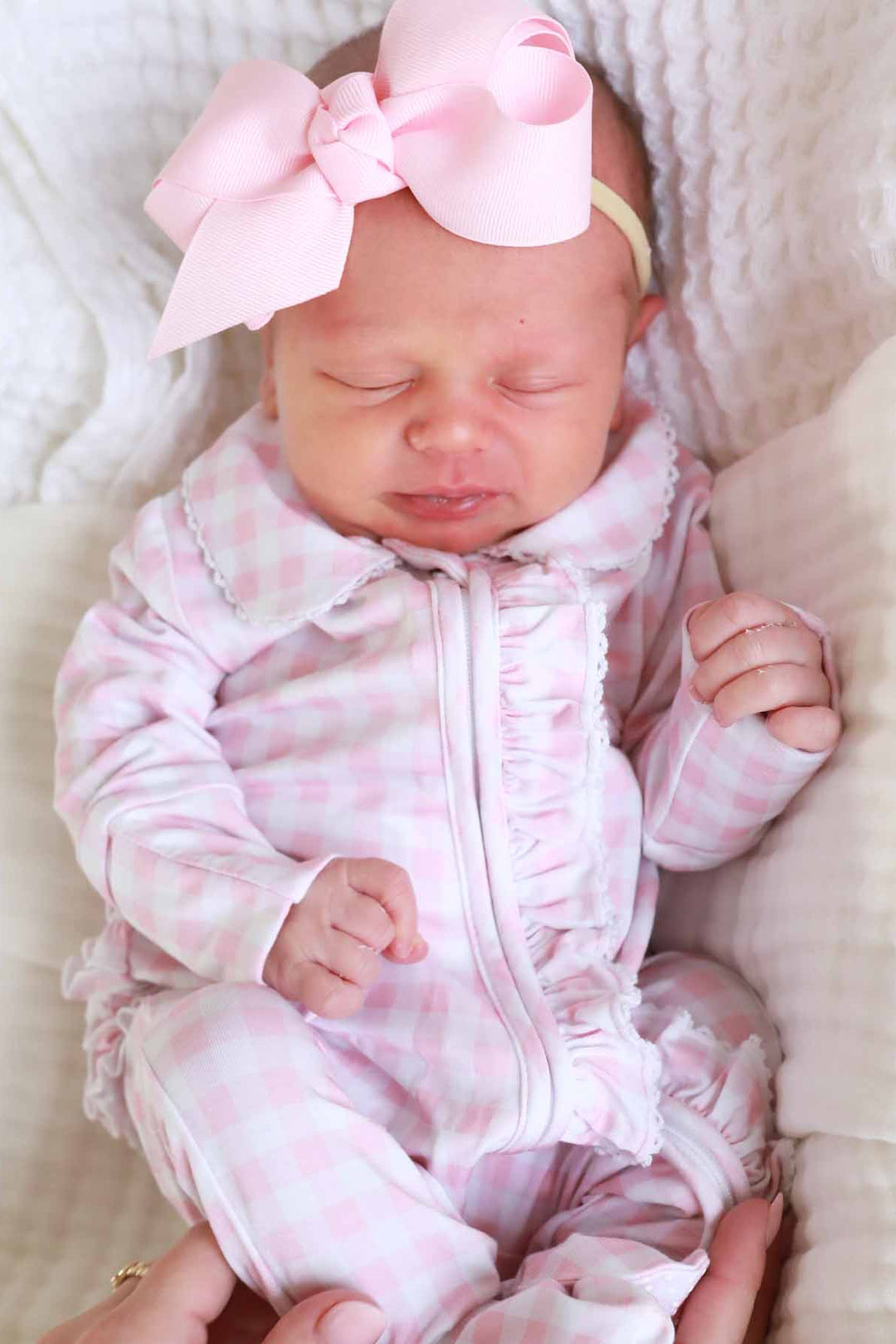 pastel pink gingham print footie pajamas with peter pan collar and ruffle detail for newborns