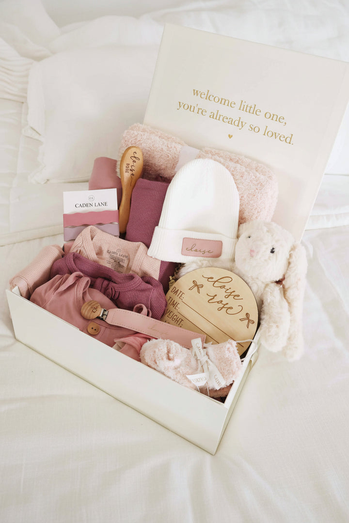 deluxe baby shower gift box bundle with pink 2pc waffle, zipper footie, knot gown, wood  stats, swaddles, bottle labels, burps, socks, paci clip, beanie, lovey, blanket, hooded towel, hair brush, bunny stuffed animal