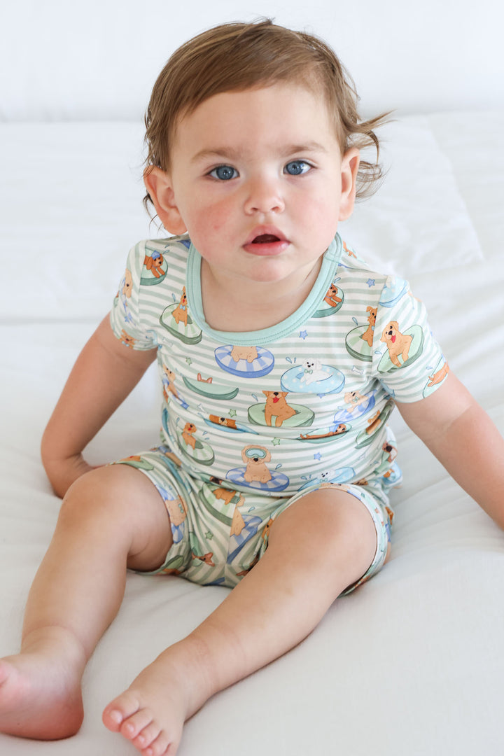 green striped pajama set with dogs on pool floaties 
