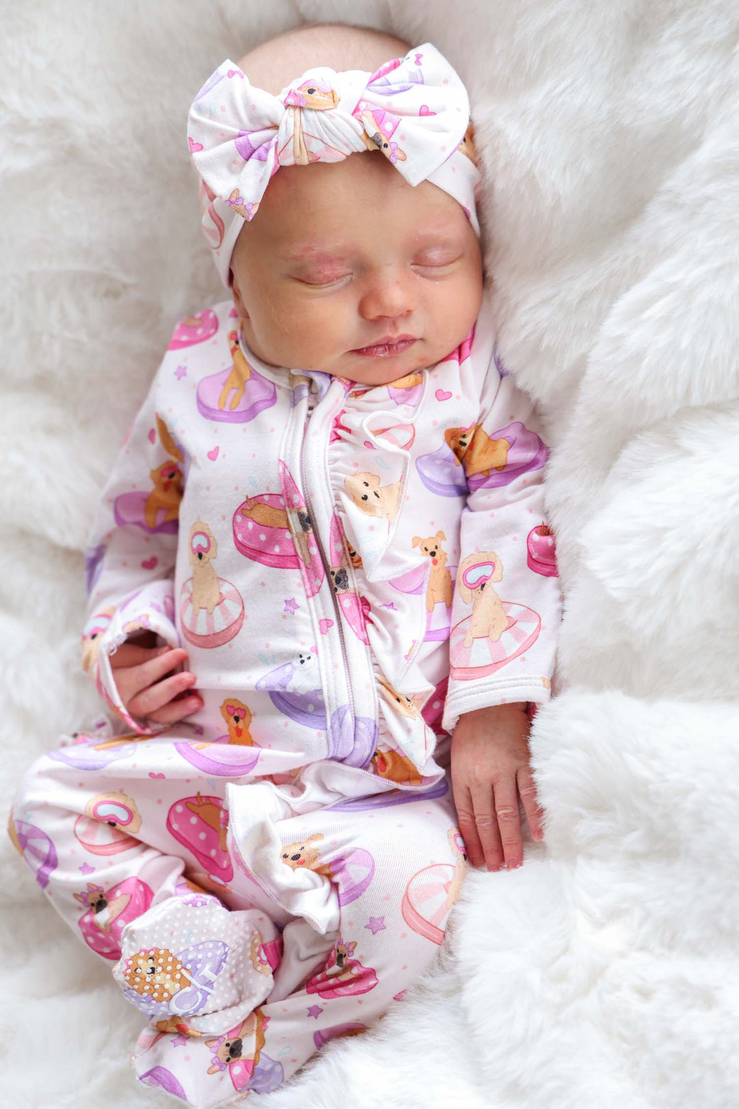 baby girl laying on blanket in pink poolside pups ruffle zipper footie