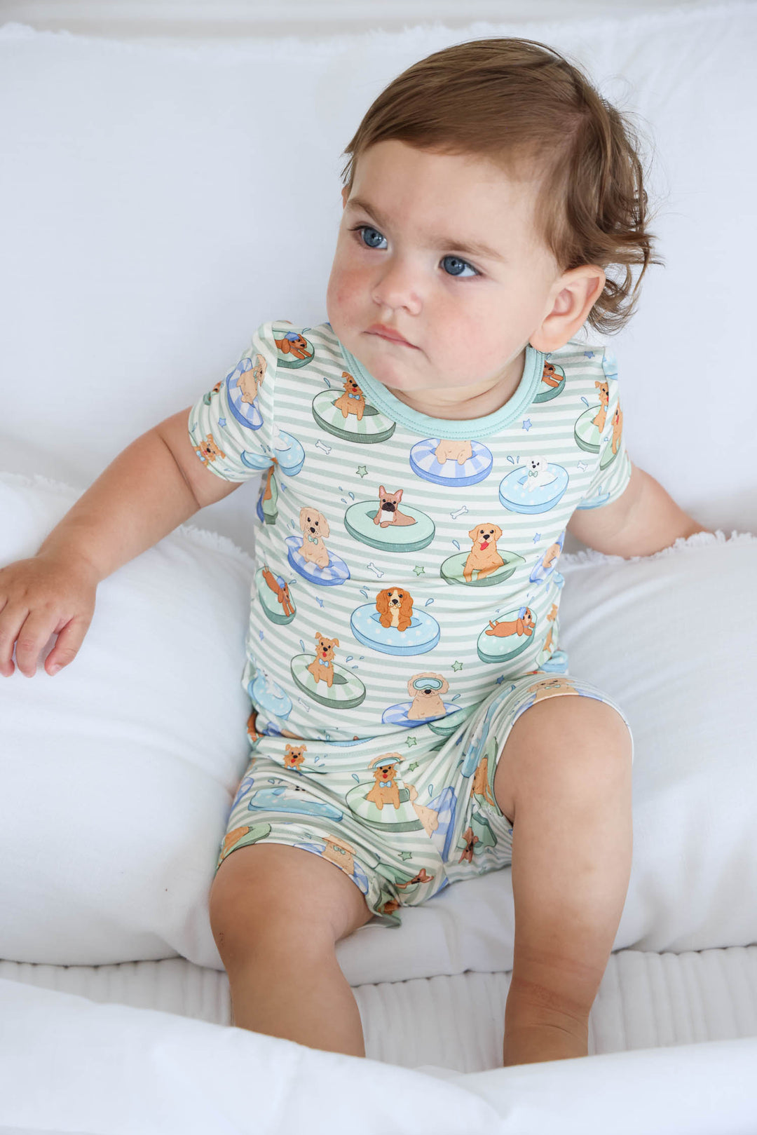boy sitting on bed in poolside pups two piece pajama set summer 