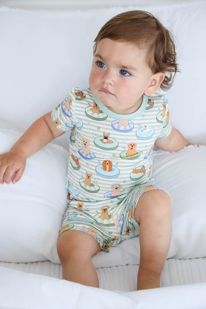 boy sitting on bed in poolside pups two piece pajama set summer 