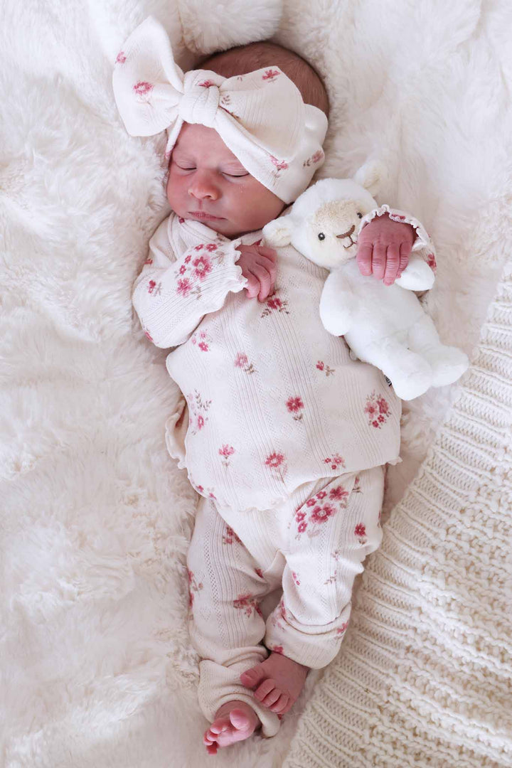  baby girl wearing a pointelle bamboo set with mauve flowers on it