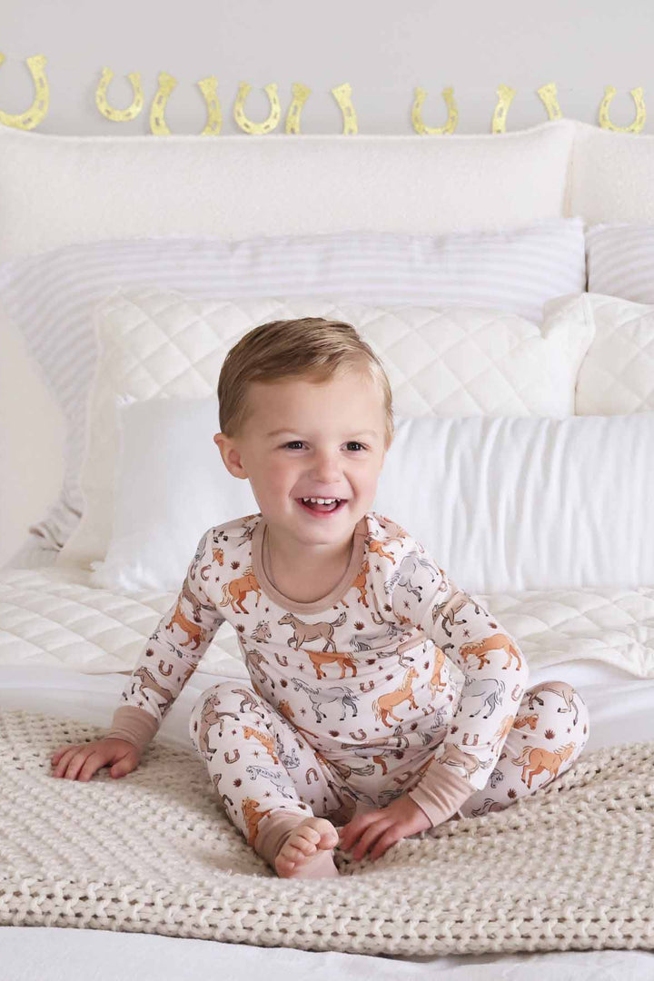 boy's two piece pajama set with ponies, horses, and horseshoes print - caden lane