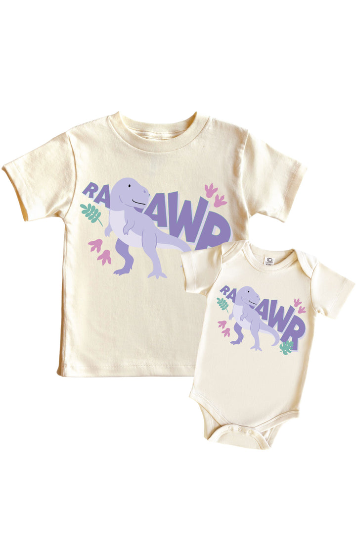Natural cream kids tee and baby bodysuit set with RAAWR text and a purple T-Rex dinosaur graphic with pink and green leaf accents