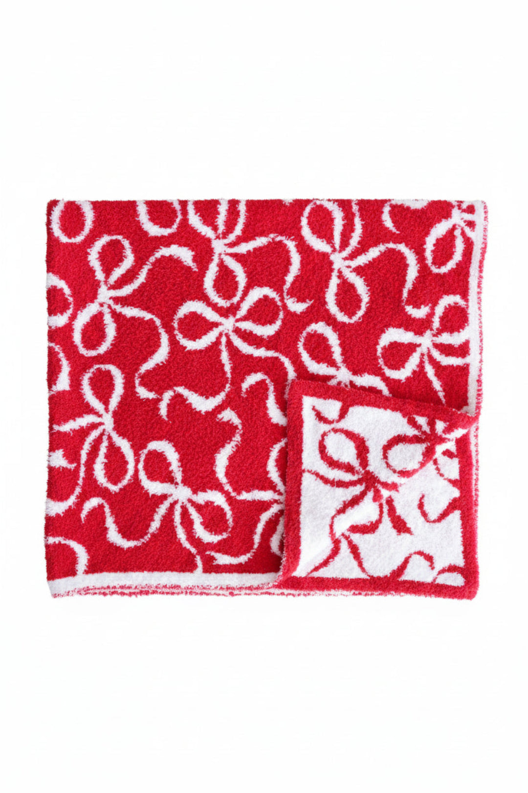 Caden Lane luxe sherpa throw blanket in red with a white bow ribbon print, shown folded flat to display both the red and white reversible sides, product photo on a white background