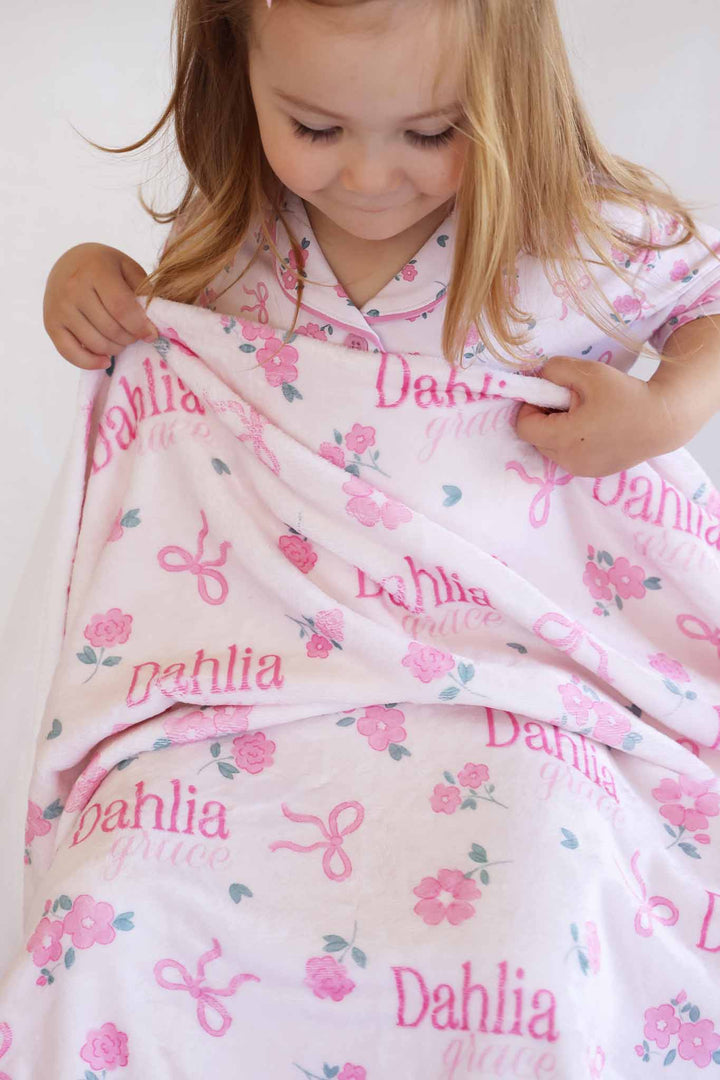 girl pulling up ribbon and roses pink personalized blanket 