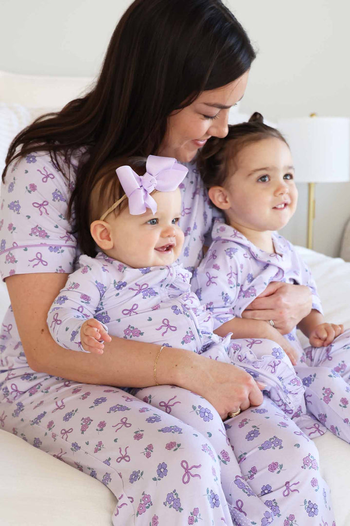 mom with two babies on her lap wearing purple flower and ribbon matching lounge sets 