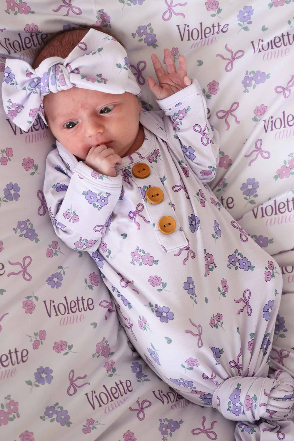newborn knot gown for baby girls with purple print of flowers and ribbon 