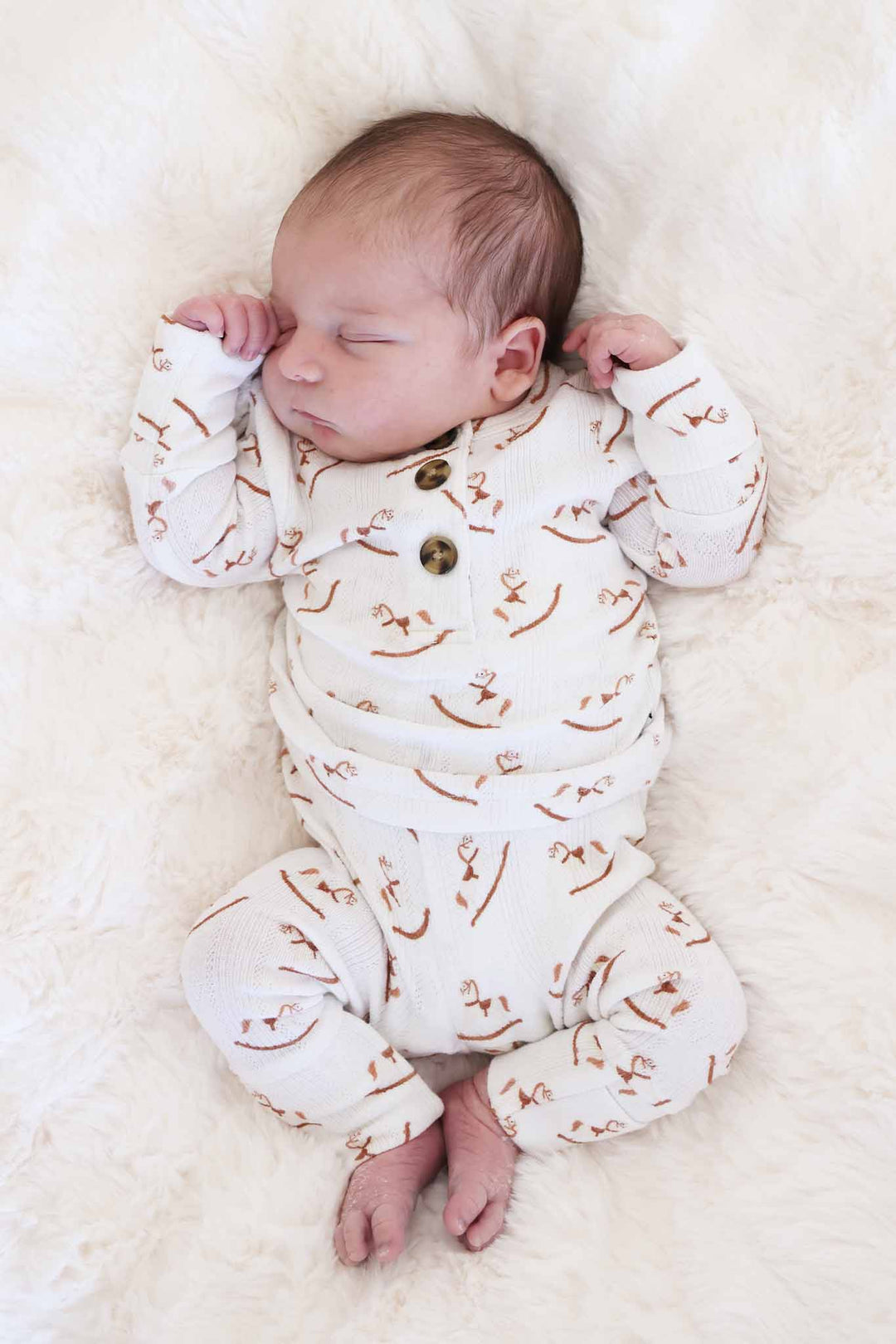 baby boy laying on blanket in 2pc pointelle bamboo set with rocking horses