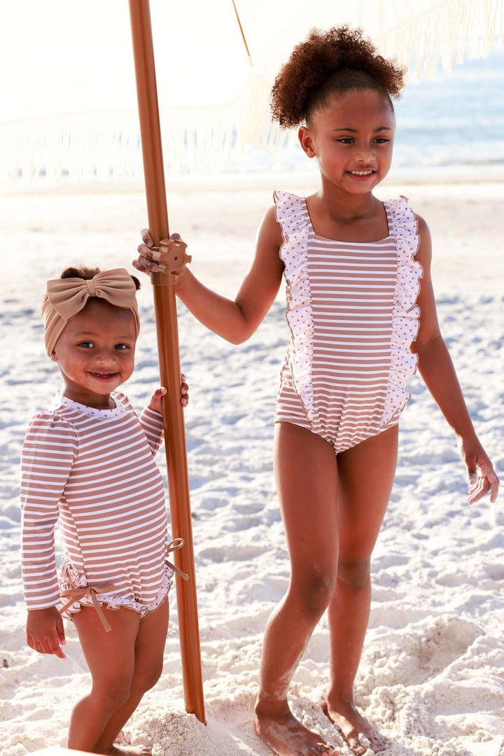 sisters in coordinating brown and white stripe swimsuit with brown polka dot accents 
