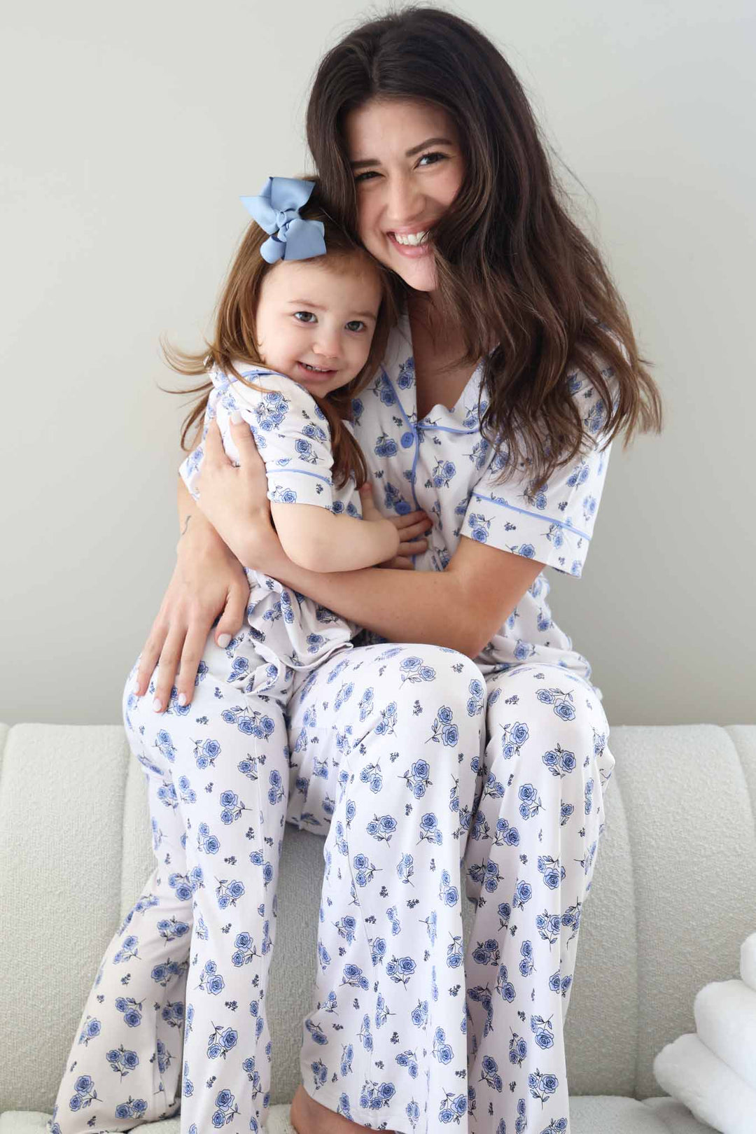 mom and daughter sitting on couch in matching blue rose flare lounge sets 