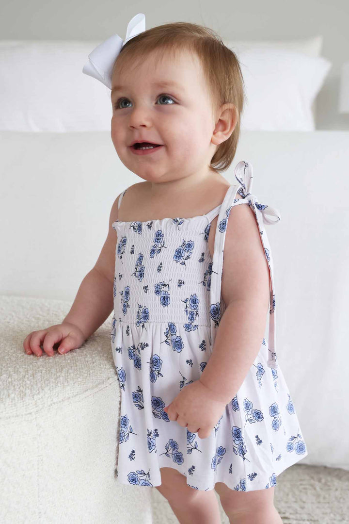 baby girl standing on ottoman in sapphire garden spaghetti strap mocked bodysuit with skirt 