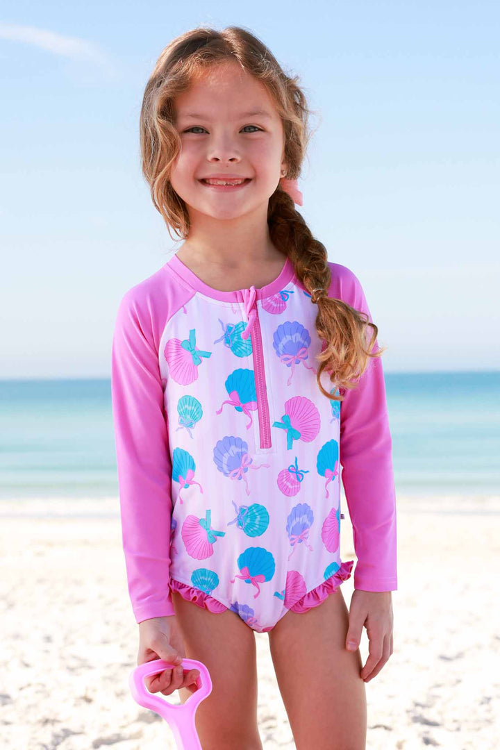 girl standing on beach in seaside sweetie front zip rash guard