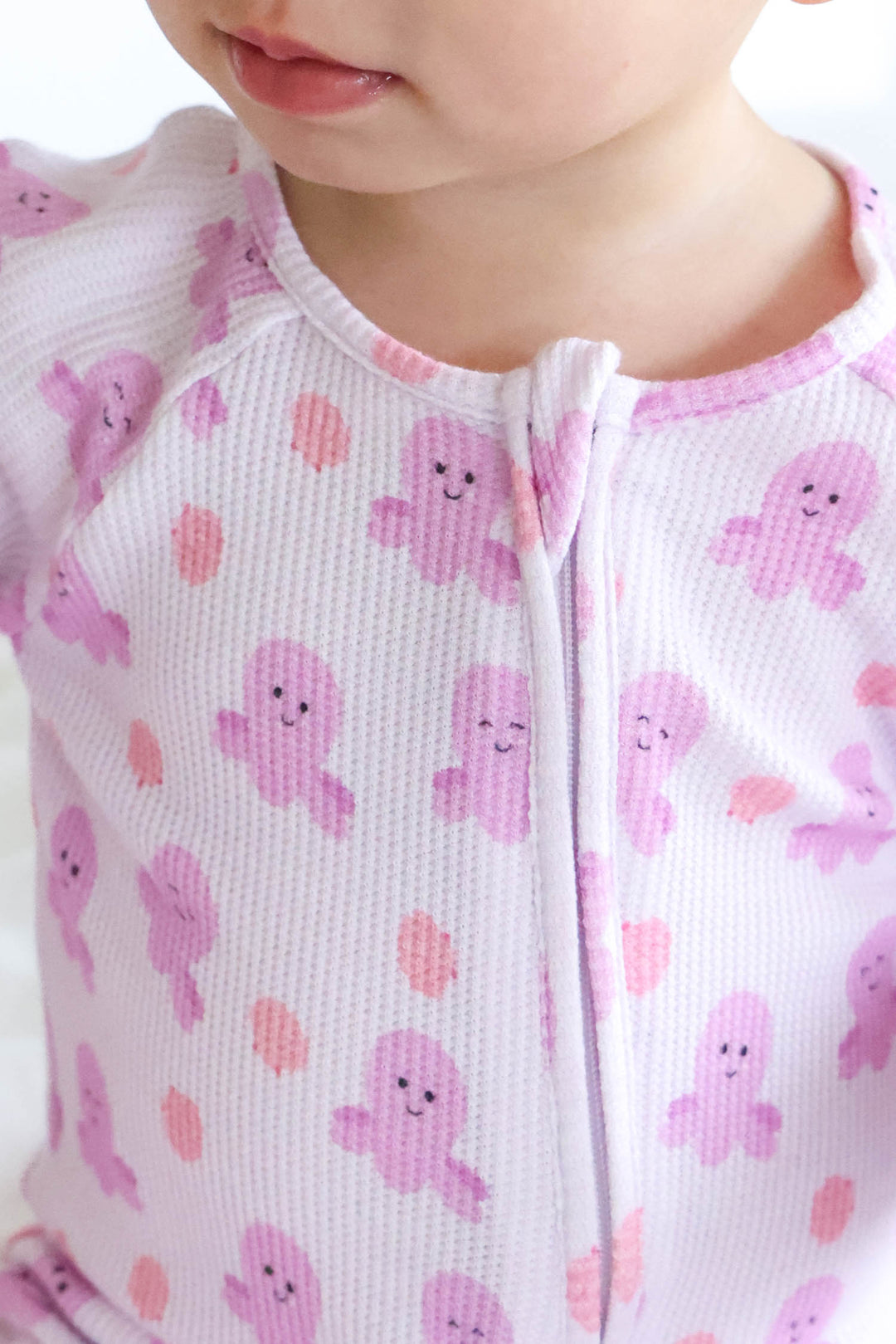close-up of neckline and zip on sea snuggles bamboo waffle convertible zip romper showing girly octopus print detail