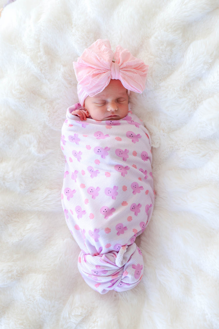 newborn swaddled in sea snuggles bamboo waffle oversized swaddle blanket — overhead view showing full swaddle with knotted bottom