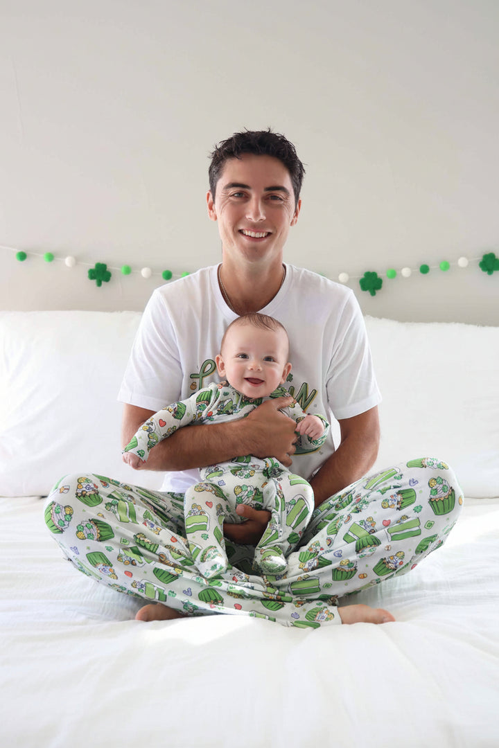 dad holding baby wearing a st. patrick's day footie with matching adult pajama pants and t-shirt 