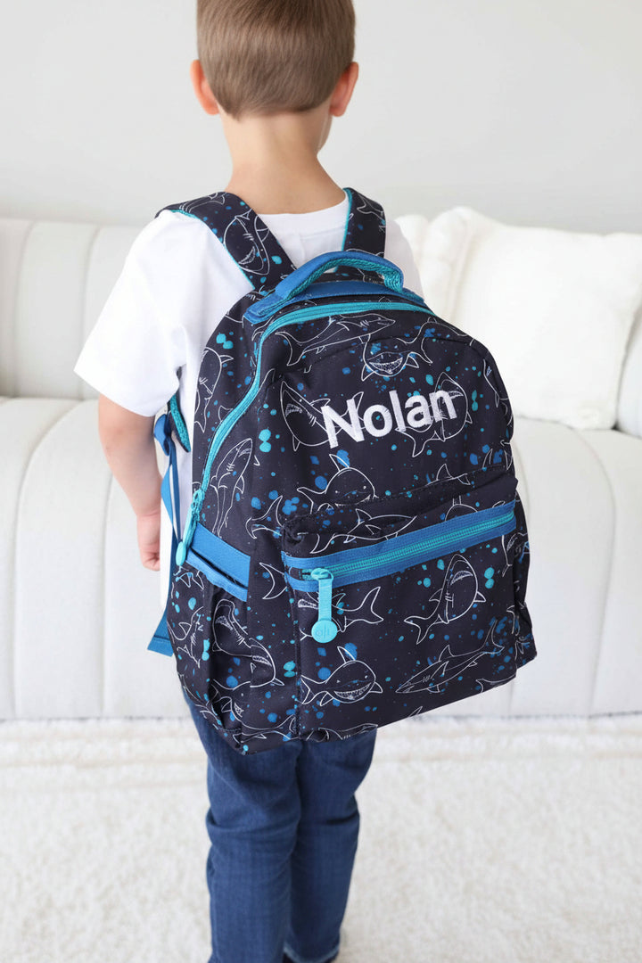 black backpack with blue zipper and white sharks embroidered with name 